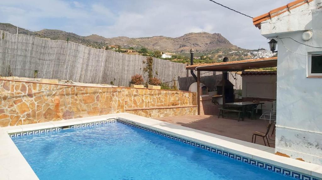 - une piscine en face d'une maison dans l'établissement Casa Rural Los Caballos Finca Canca Alora Caminito del Rey, à Alora