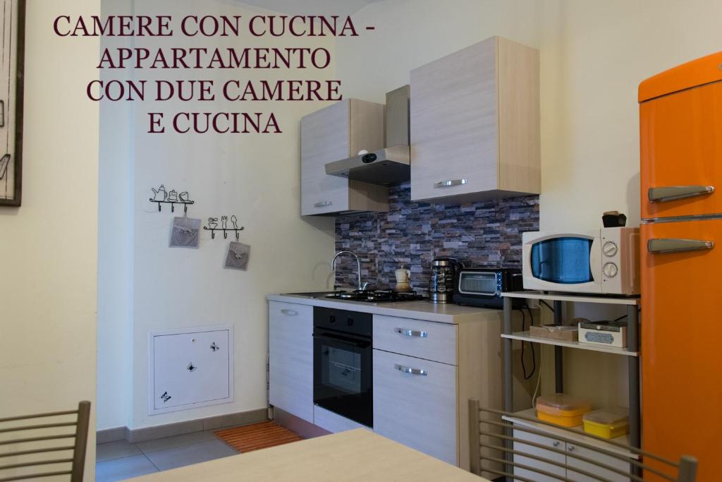 y cocina con fogones y microondas. en Melibi - Re Lear Apartments, en Verona