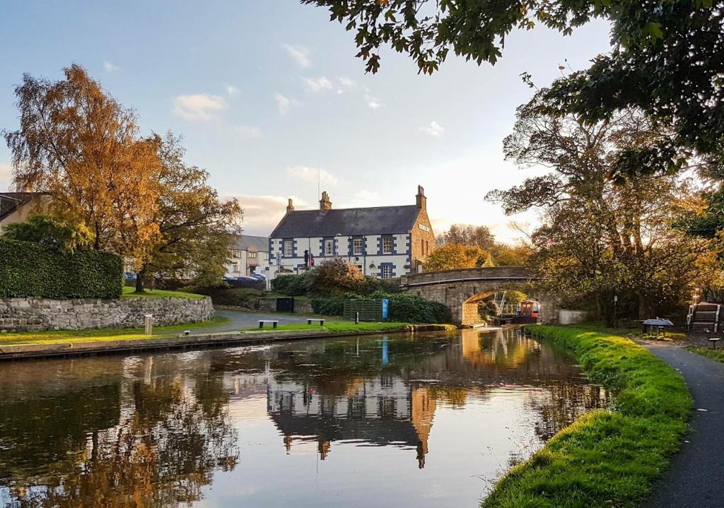 a river in front of a house and a bridge at The Bridge Inn in Ratho