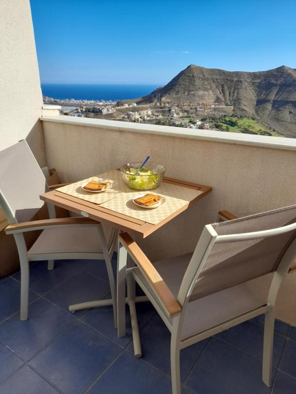 einen Tisch und Stühle auf einem Balkon mit Aussicht in der Unterkunft TAÍNA Apartamento in La Envia