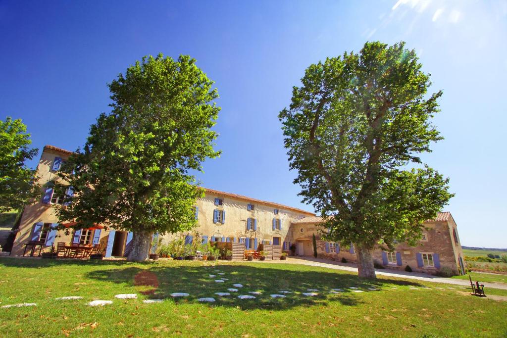 un grand bâtiment avec deux arbres devant lui dans l'établissement Domaine de Garille, à Aragon