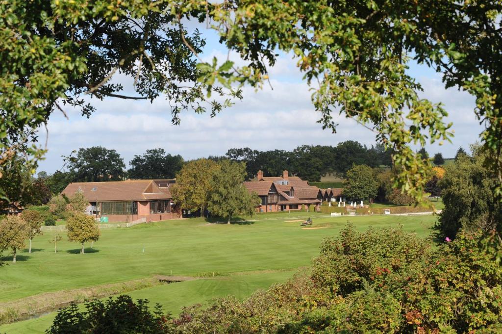 uitzicht op een golfbaan met een huis bij Barnham Broom Hotel, Golf & Spa in Norwich