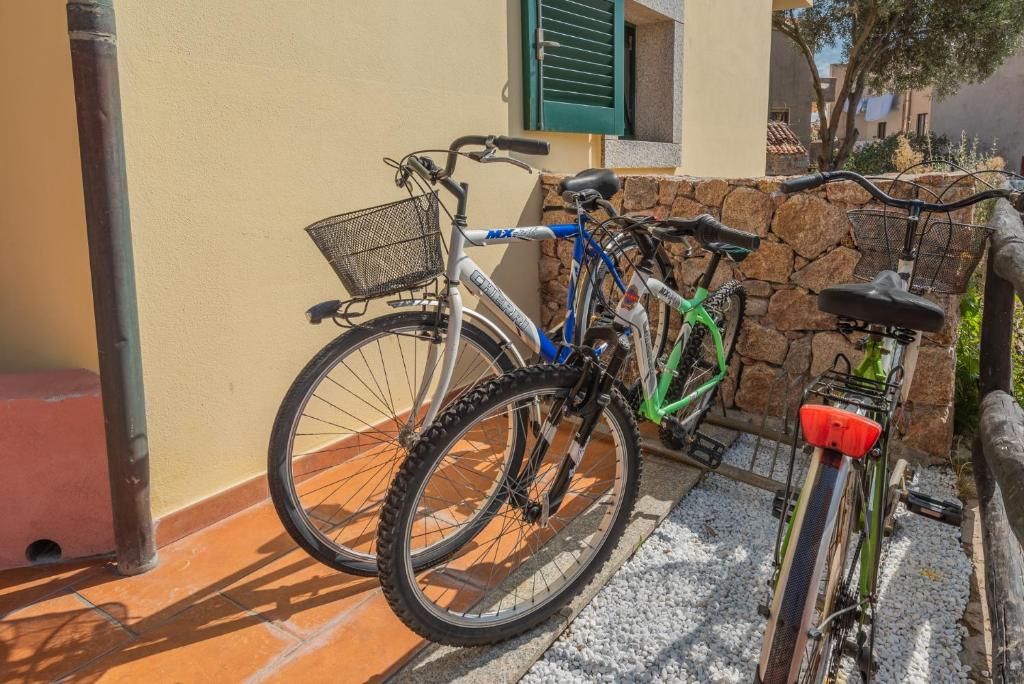 dos bicicletas están estacionadas al lado de un edificio en Residence I Mirti Bianchi, en Santa Teresa Gallura