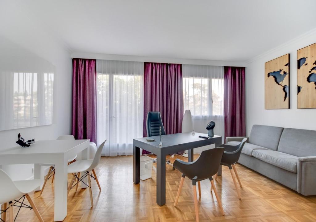 a living room with a couch and a table and chairs at Fauriel Aimé in Saint-Étienne