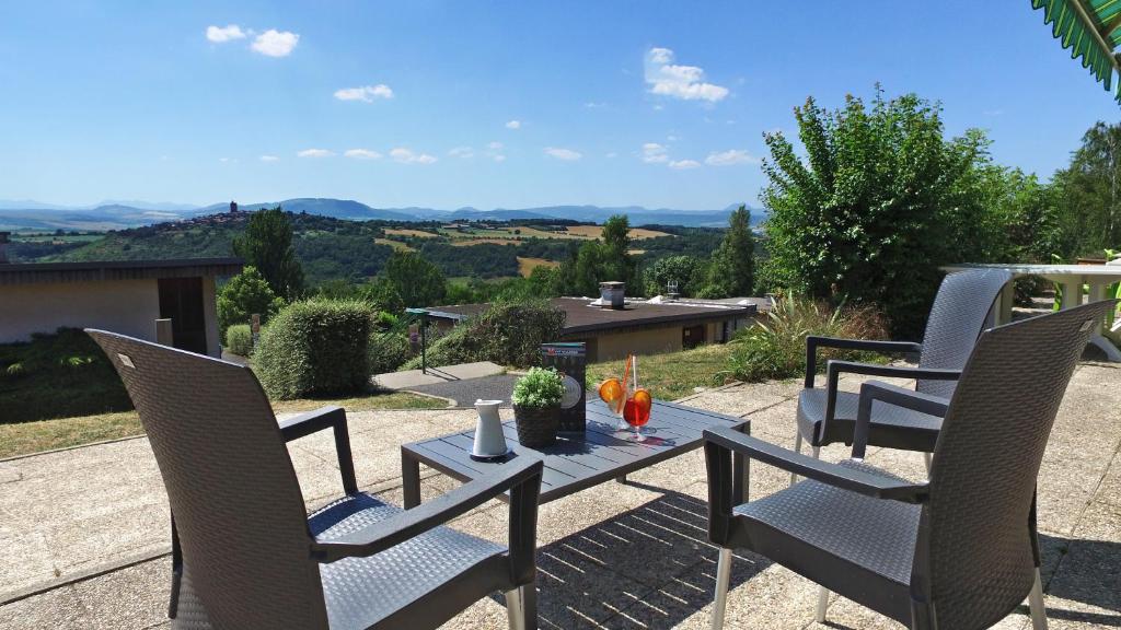 una mesa y sillas en un patio con vistas en VVF Montpeyroux Auvergne, en Parent