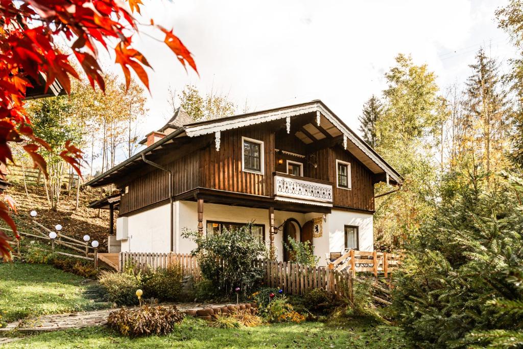 uma casa de madeira com uma cerca em frente em Alpin Chalets Wagrain em Hofmarkt