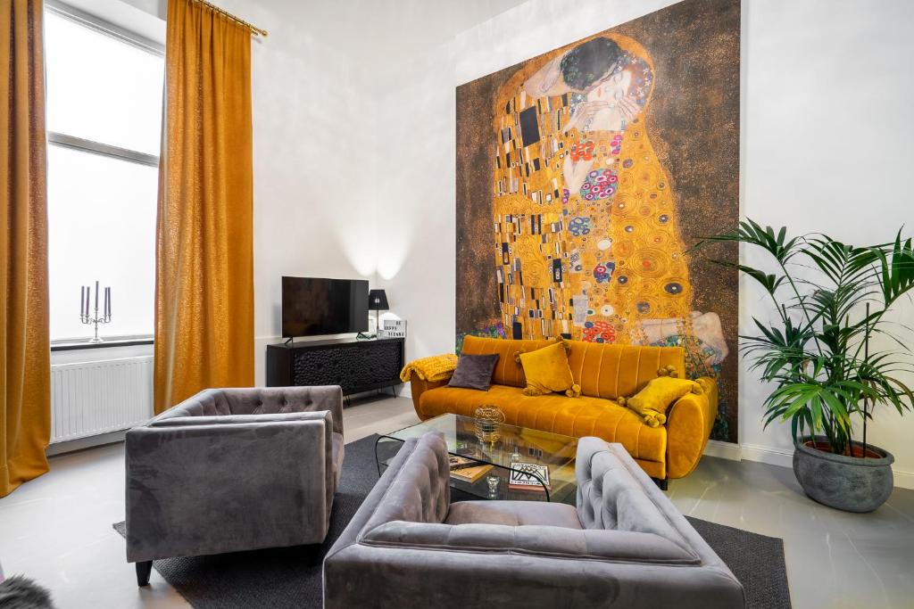 un salon avec un canapé jaune et un tableau dans l'établissement The Kiss - Luxuriöses City Loft am Naschmarkt, à Vienne