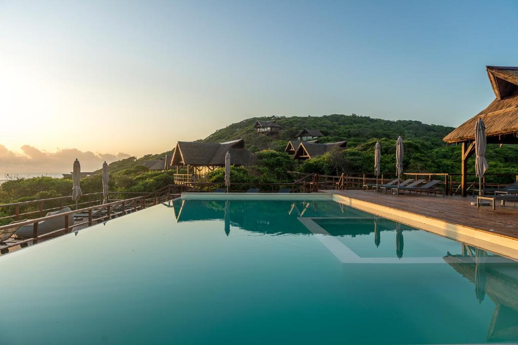 uma piscina com água azul em frente a um resort em Montebelo Milibangalala Bay Resort em Maputo