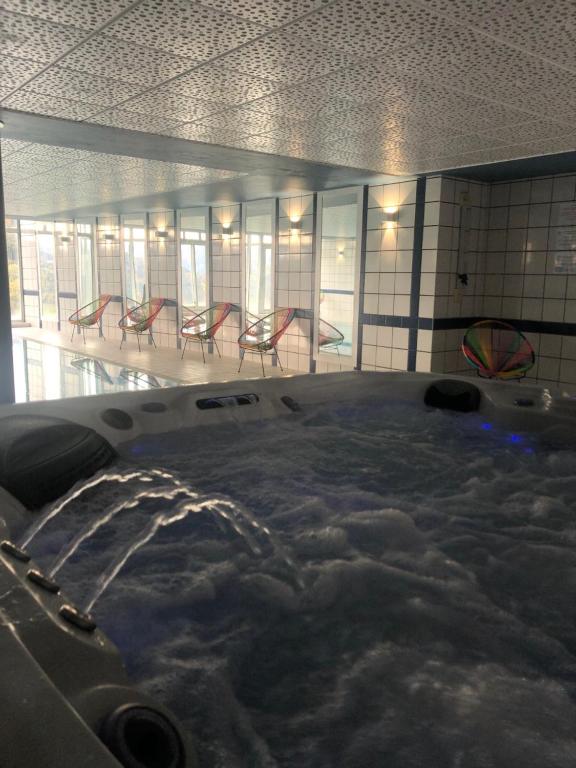 a hot tub with snow in a room with chairs at Hôtel Panorama in Munster