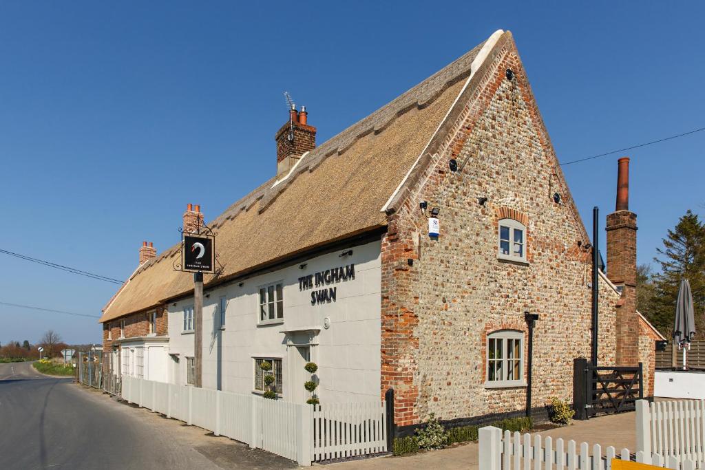 an old brick building on the side of a street at The Ingham Swan in Stalham