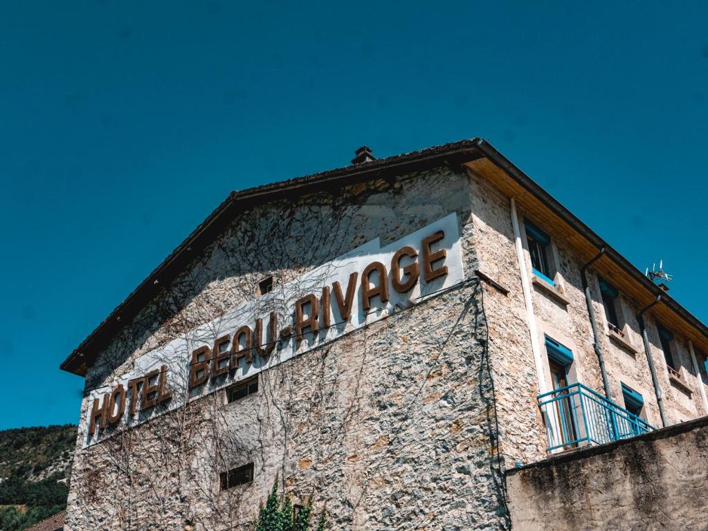 una señal en el lateral de un edificio en Hotel Beau Rivage, en Pont-en-Royans