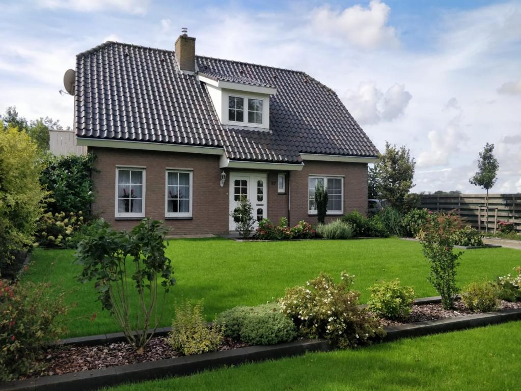 a house with a green yard at Groot familiehuis voor 6 personen in landelijke, rustige omgeving in Breezand