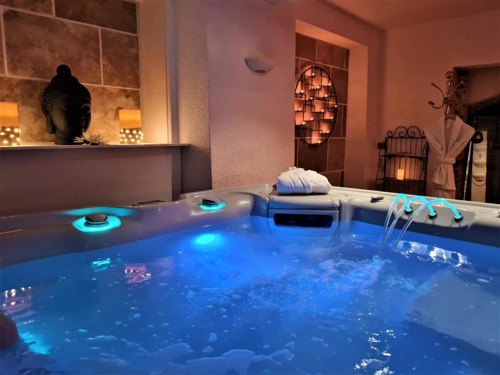 une baignoire jacuzzi avec éclairage bleu dans une chambre dans l'établissement Châtellerie De Schoebeque, à Cassel