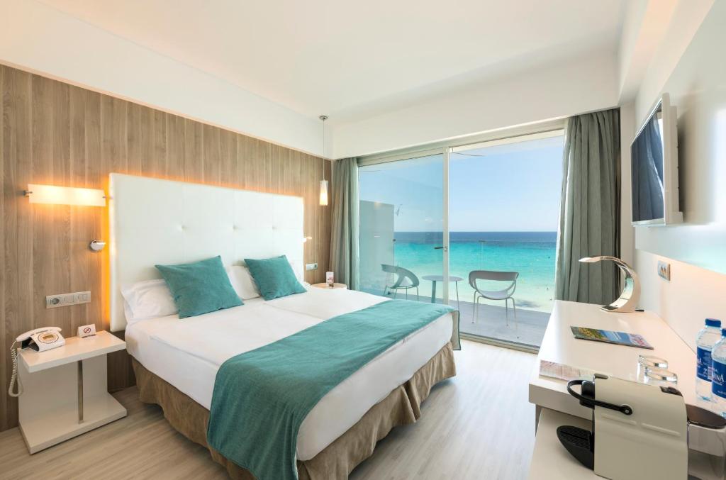 a hotel room with a bed and a view of the ocean at Kyrat Amarac - Adults Only in Cala Millor