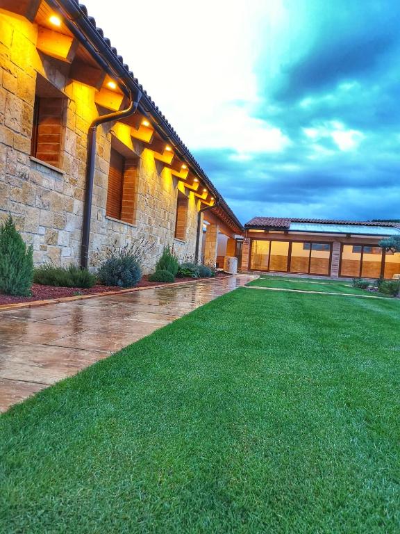 a house with a lawn in front of a building at La Mañica in La Vilueña