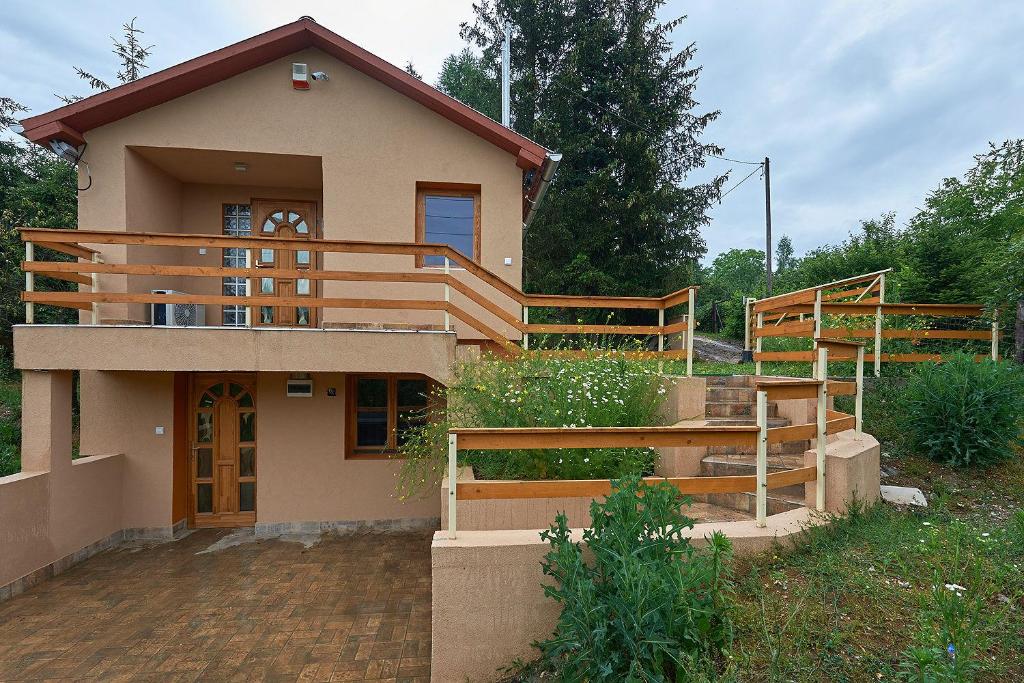 a house with wooden stairs in front of it at Patkó Apartman, Miskolctapolca in Miskolc