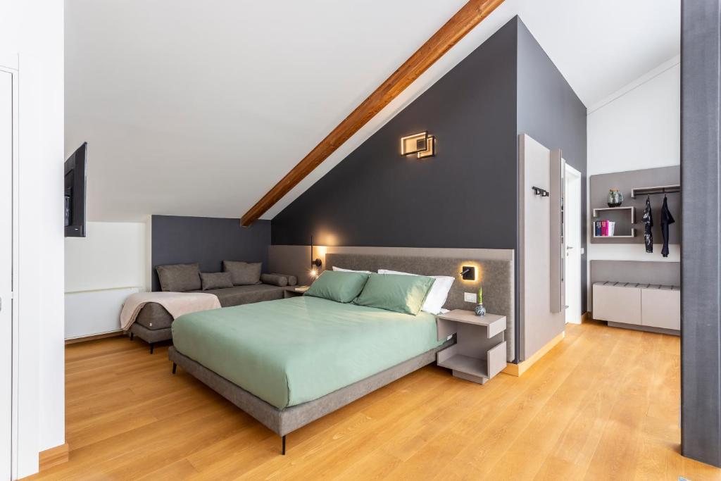 a bedroom with a green bed and a couch at Habitat Guest House in Trento