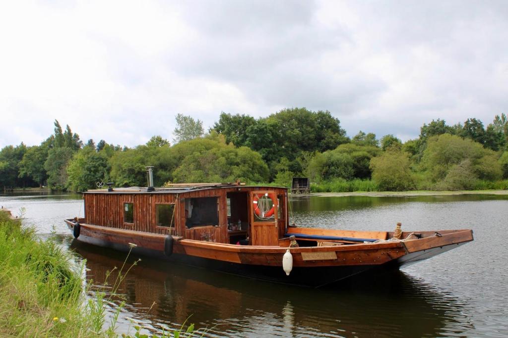 un vieux bateau est assis dans l'eau dans l'établissement La Toue de Blain, à Blain