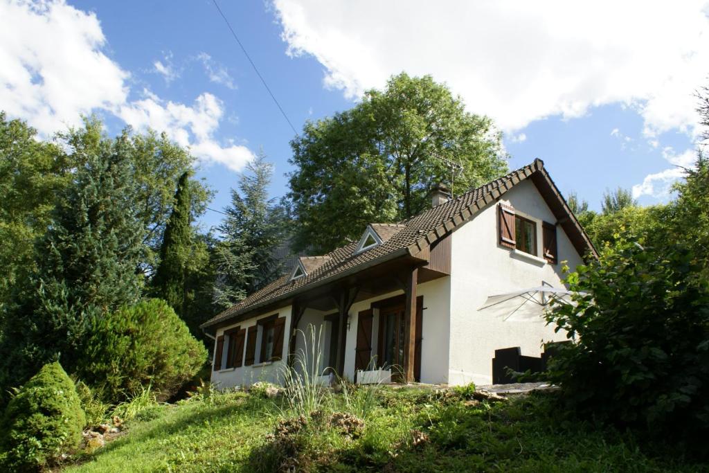 ein kleines weißes Haus auf einem Hügel mit Bäumen in der Unterkunft Entre Phare et Moulin in Verzenay