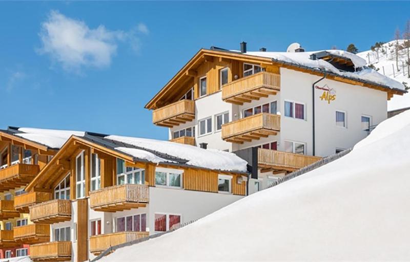 un edificio ricoperto di neve con balconi in legno su una montagna di Fewo-Obertauern Alps a Obertauern