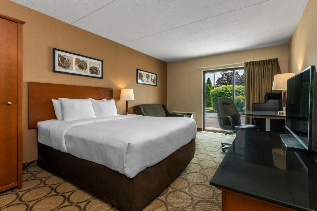 a hotel room with a bed and a television at Comfort Inn Orillia in Orillia