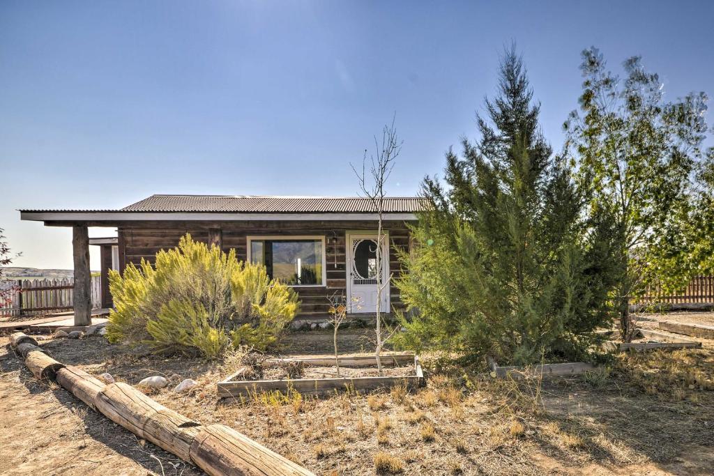 une petite maison avec des arbres devant elle dans l'établissement Hundred-Year-Old Shell Valley Settlers Cabin!, à Shell