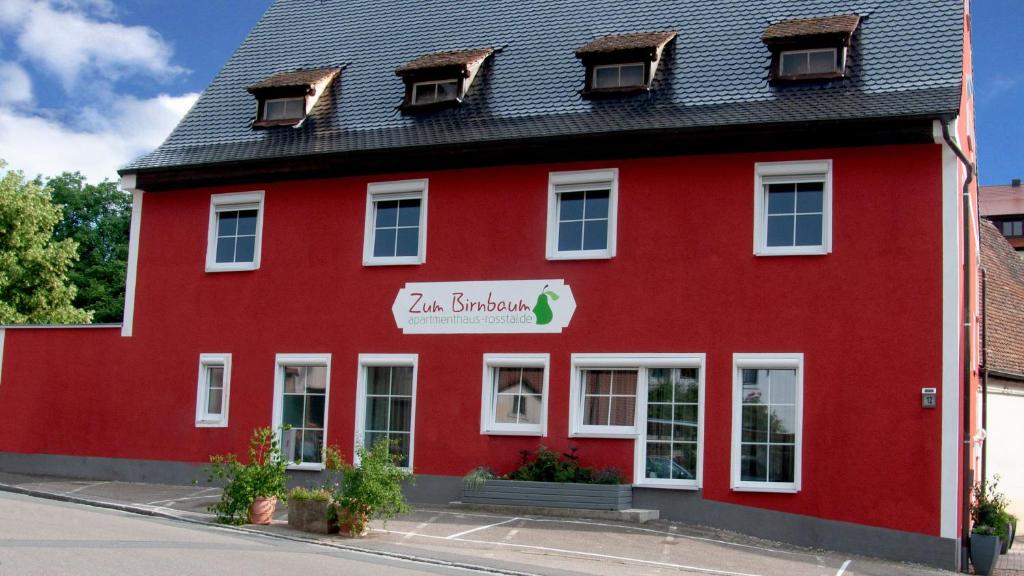 a red building with a sign on it at Apartmenthaus "Zum Birnbaum" in Roßtal