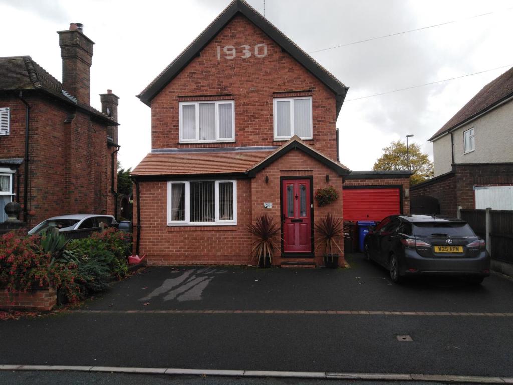 a red brick house with a red door at 24 Fairfield Road in Uttoxeter