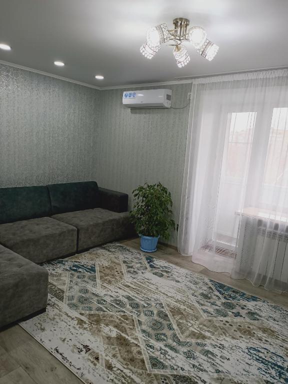 a living room with a couch and a rug at ApartLux on Slavskogo 14 in Ustʼ-Kamenogorsk