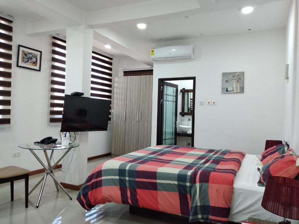 1 dormitorio con 1 cama y TV. en Van Der Salle, en Accra