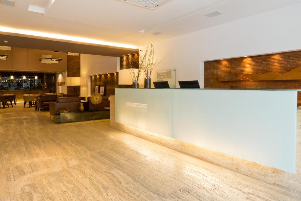 a lobby with a reception desk and a bar at Ritz Leblon in Rio de Janeiro
