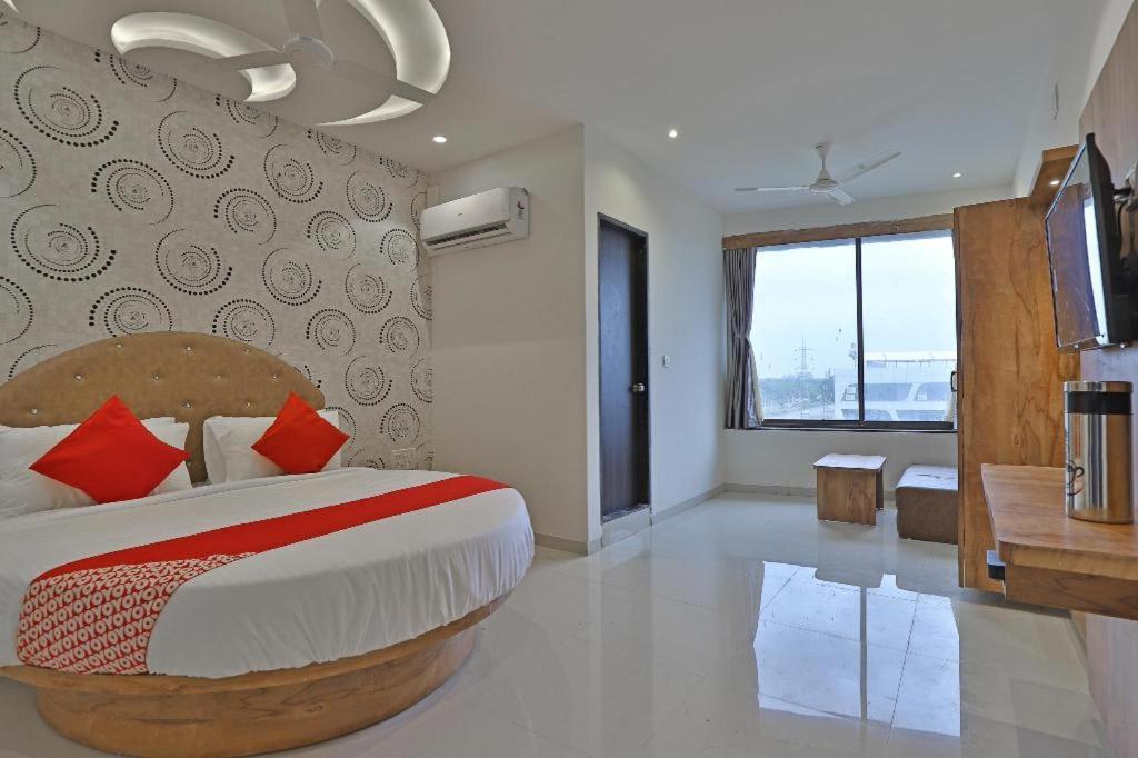 ein Schlafzimmer mit einem großen Bett und einem großen Fenster in der Unterkunft hotel hill city in Gandhinagar