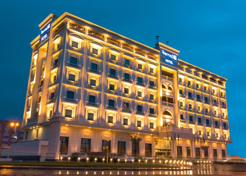 a large white building with lights in front of it at Remaj Hotel in Taif