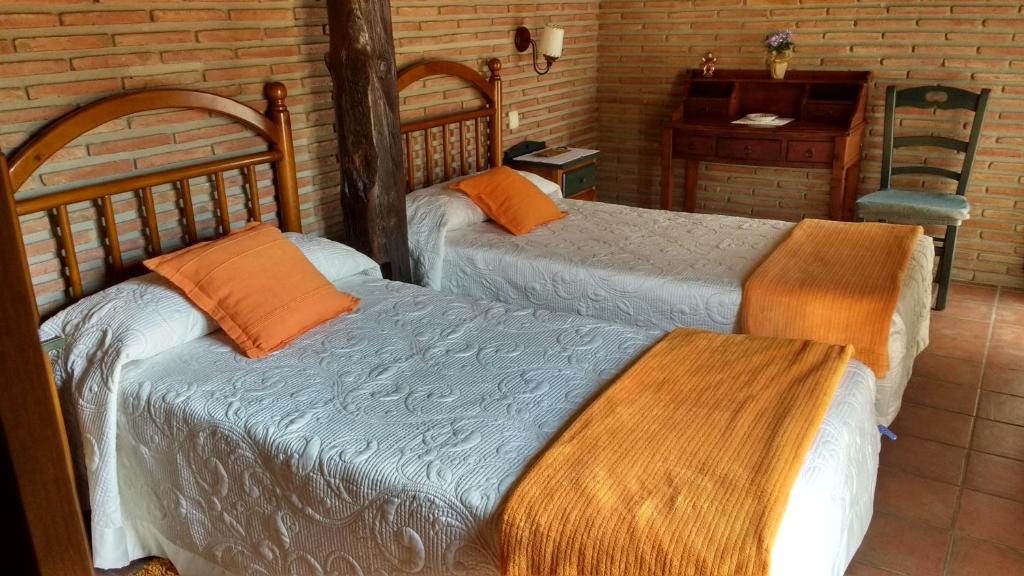 1 dormitorio con 2 camas, mesa y escritorio en Casa rural La Media Legua en Villoslada de Cameros