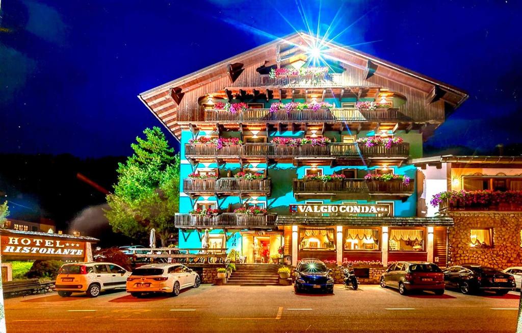 a building with cars parked in a parking lot at Hotel Valgioconda in Sappada