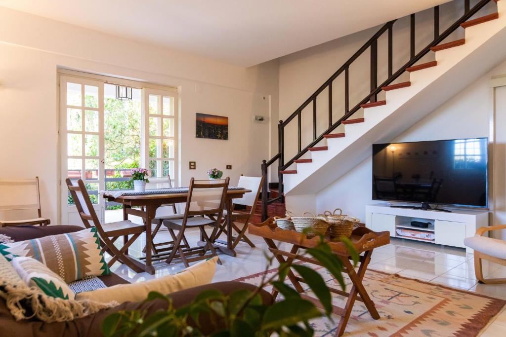 Una sala de estar con un sofá y una mesa con televisión. en Casa Pitea, en Mondello