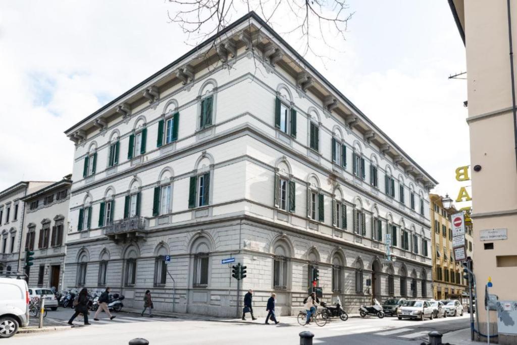 Ein weißes Gebäude an einer Stadtstraße, an der Leute vorbeigehen. in der Unterkunft Hotel St. James in Florenz