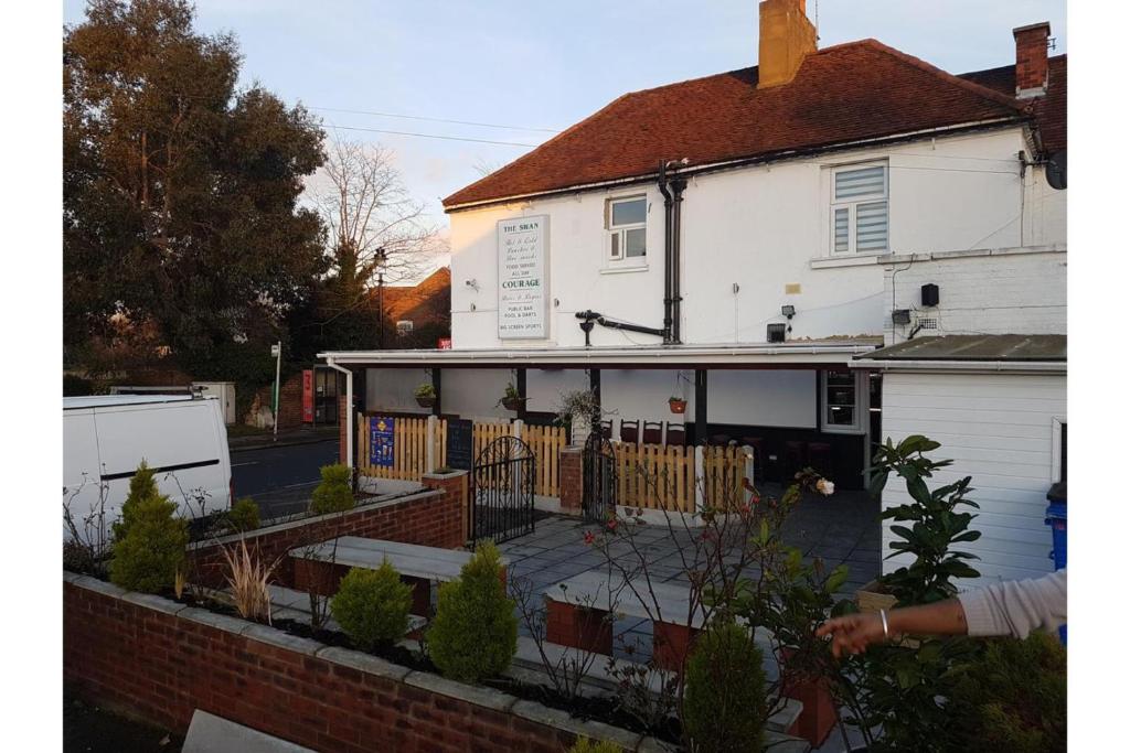 a white house with a patio in front of it at Oyo Swan Inn, Heathrow Airport in Stanwell