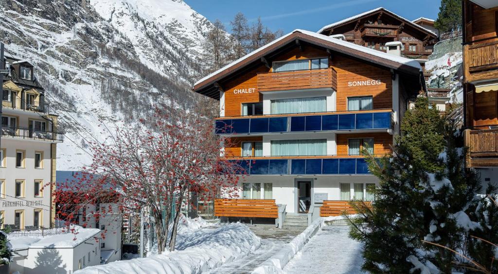 a building in the snow with a mountain at Chalet Sonnegg in Zermatt