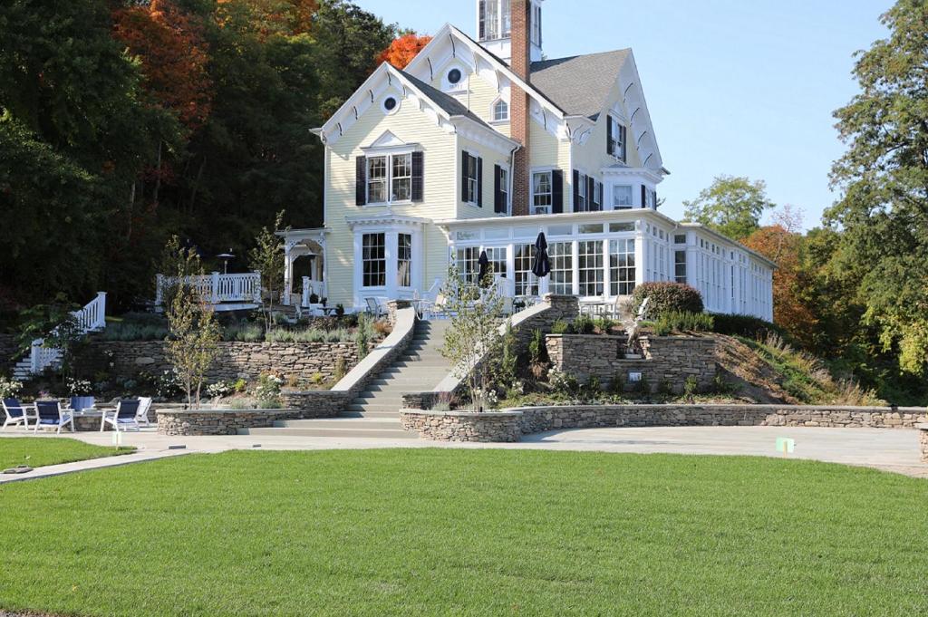 uma grande casa branca com um relvado em frente em Inn at Taughannock Falls em Ithaca