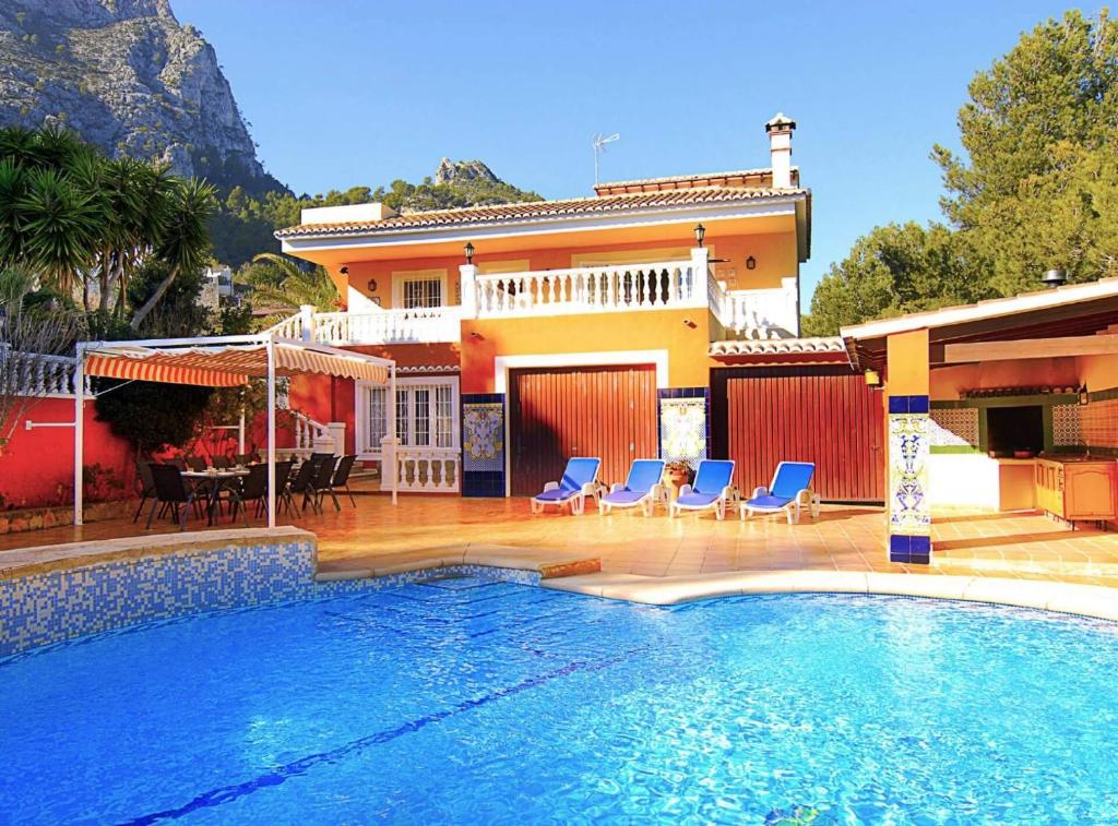 a house with a swimming pool in front of a house at Villa Miguel - Plusholidays in Benissa