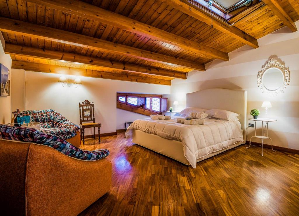 敘拉古的住宿－La Casa di Ilde al Duomo - Ortigia Holidays，一间大卧室,配有一张大床和一张沙发