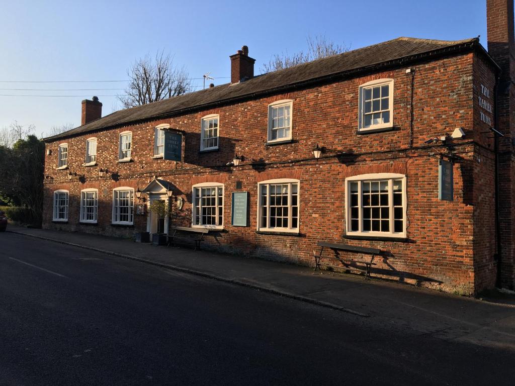 a brick building with a bench in front of it at Three Tuns Ashwell in Ashwell