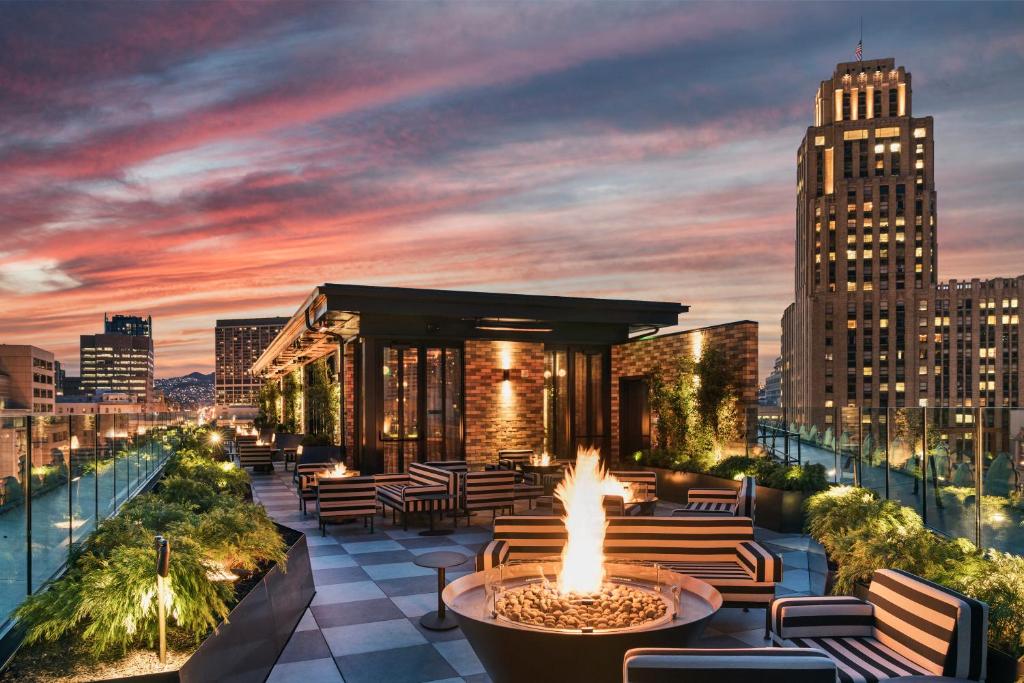 a rooftop patio with a fire pit and a city skyline at San Francisco Proper Hotel, a Member of Design Hotels in San Francisco