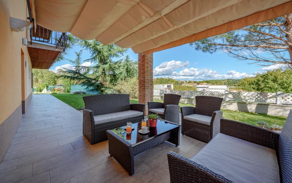 eine Terrasse mit Korbstühlen und einem Tisch in der Unterkunft Apartman Giovi in Pazin