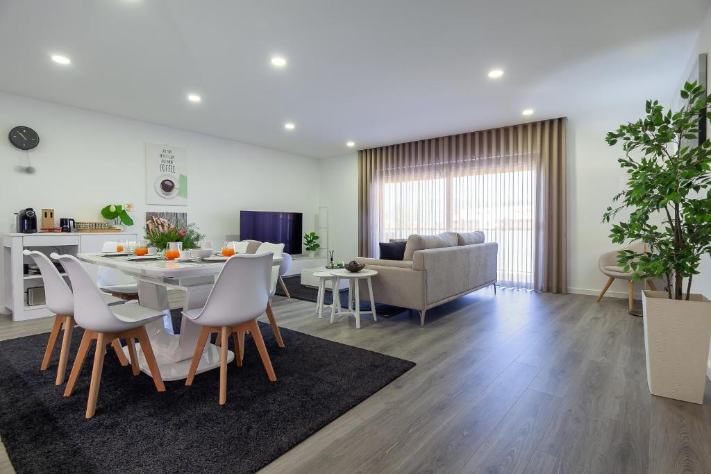 een eetkamer en een woonkamer met een tafel en stoelen bij LED Apartment - Vista Alegre in Ponte de Lima