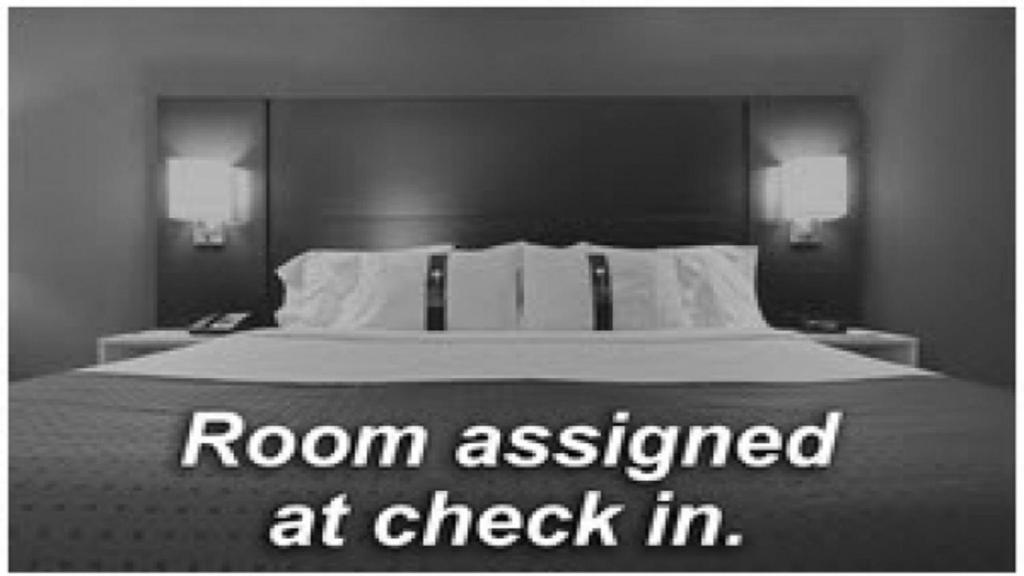 Holiday Inn Express Hotel & Suites Barrie, an IHG Hotel في باري: غرفة نوم مع سرير مع غرفة مخصصة عند تسجيل الوصول