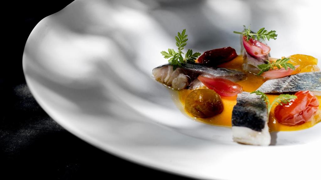 a white plate with a dish of food on it at Zenit Convento San Martin in San Sebastián