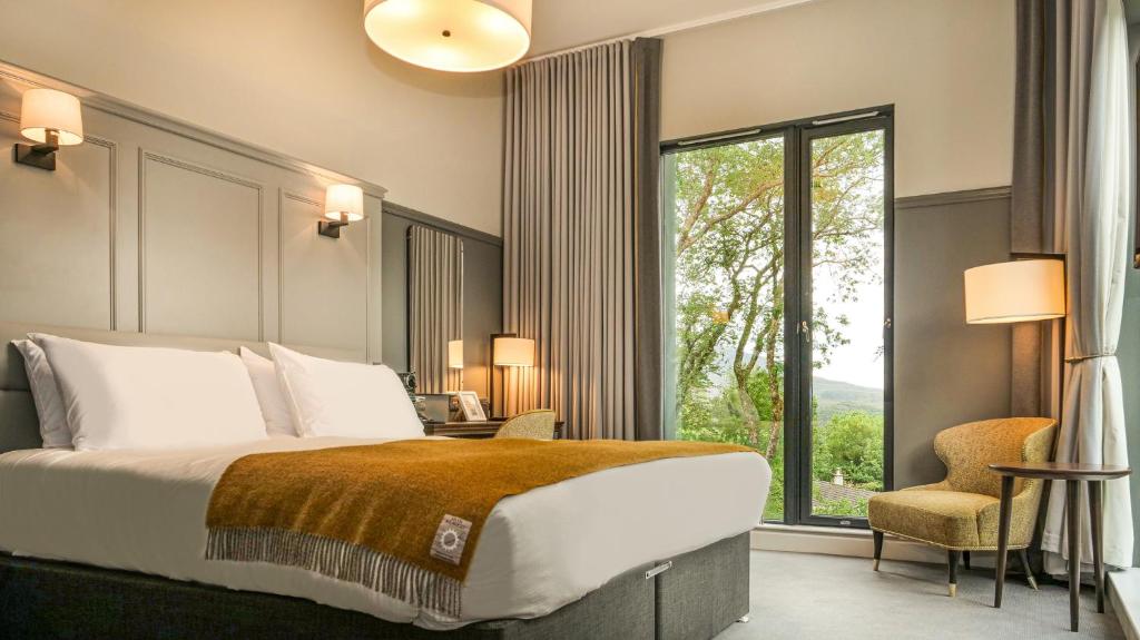 sypialnia z dużym łóżkiem i dużym oknem w obiekcie Marmalade w mieście Portree