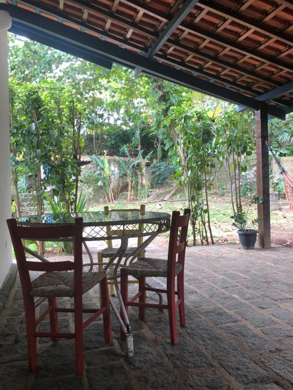 una mesa y sillas en un patio con árboles en Casa Praia da Vila, en Ilhabela